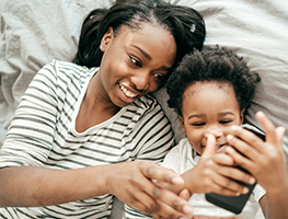 Mom and  toddler looking at a mobile phone