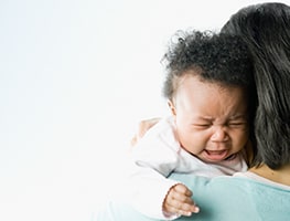 Crying baby on mom's shoulder