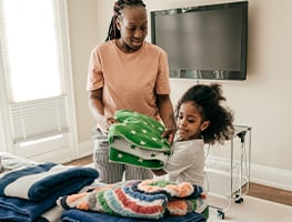 Young girl helping mom carrying towels