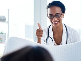 Doctor showing thumbs up to woman in labour