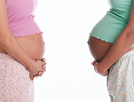 Two pregnant women holding their bellies