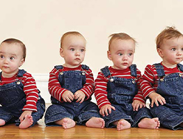 Quadruplets dressed in denim and red shirts