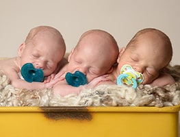 Sleeping triplets sucking on dummies