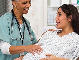 Midwife standing beside a pregnant woman
