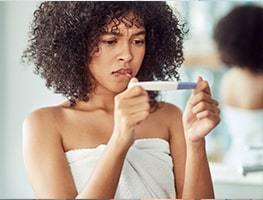 Woman looking at a negative pregnancy test