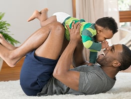 Dad playing with a smiling baby