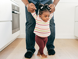 Dad helping a baby walk