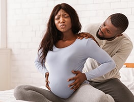 Man supporting his pregnant partner experiencing labour pains