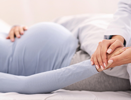 Doctor holding a pregnant woman's hand