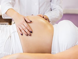 Health professional examining a pregnant belly