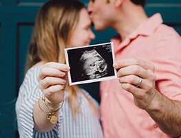 Mom and Dad holding up an ultrasound picture