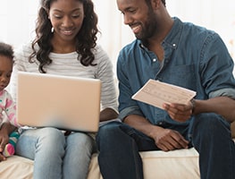 Couple and a child on a couch looking at cost of raising a child