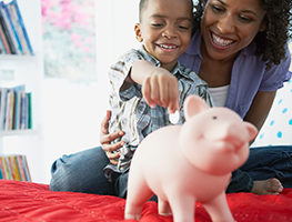 Mom and son putting coin into a piggy bank