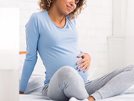 Pregnant woman holding her belly in discomfort