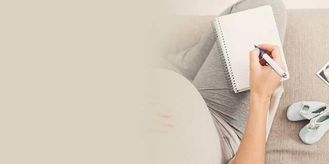 Pregnant woman with notepad and pen