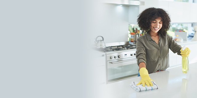 Smiling woman cleaning a kitchen surface