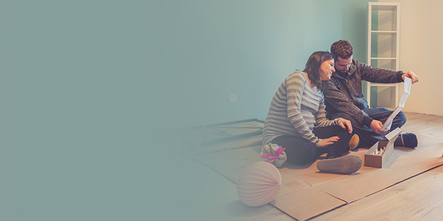 Parents-to-be sitting on a baby nursery floor