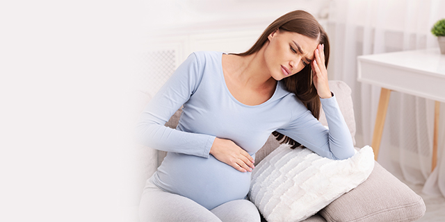 Pregnant woman holding her belly in discomfort